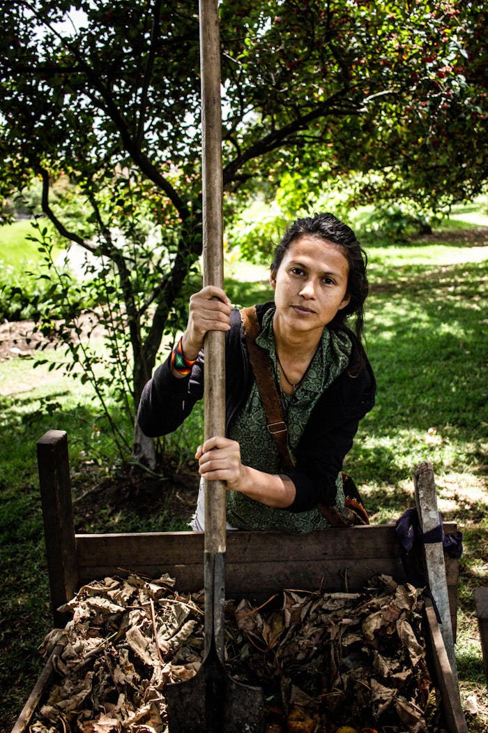 bts-img-01 A woman tending to a garden using a spade in a sunlit setting in Bogotá, Colombia.