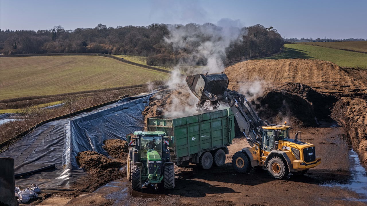 Aerial view of industrial composting operations with machinery in action on a clear day.
