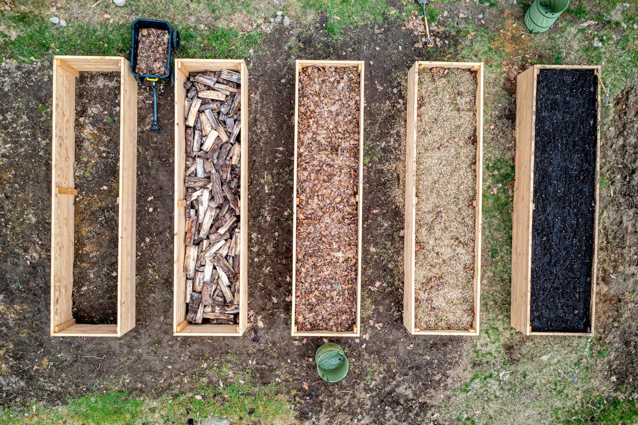 my-work-01 Top view of wooden boxes with piles of firewood wood chips sawdust and coal placed on ground in agricultural plantation